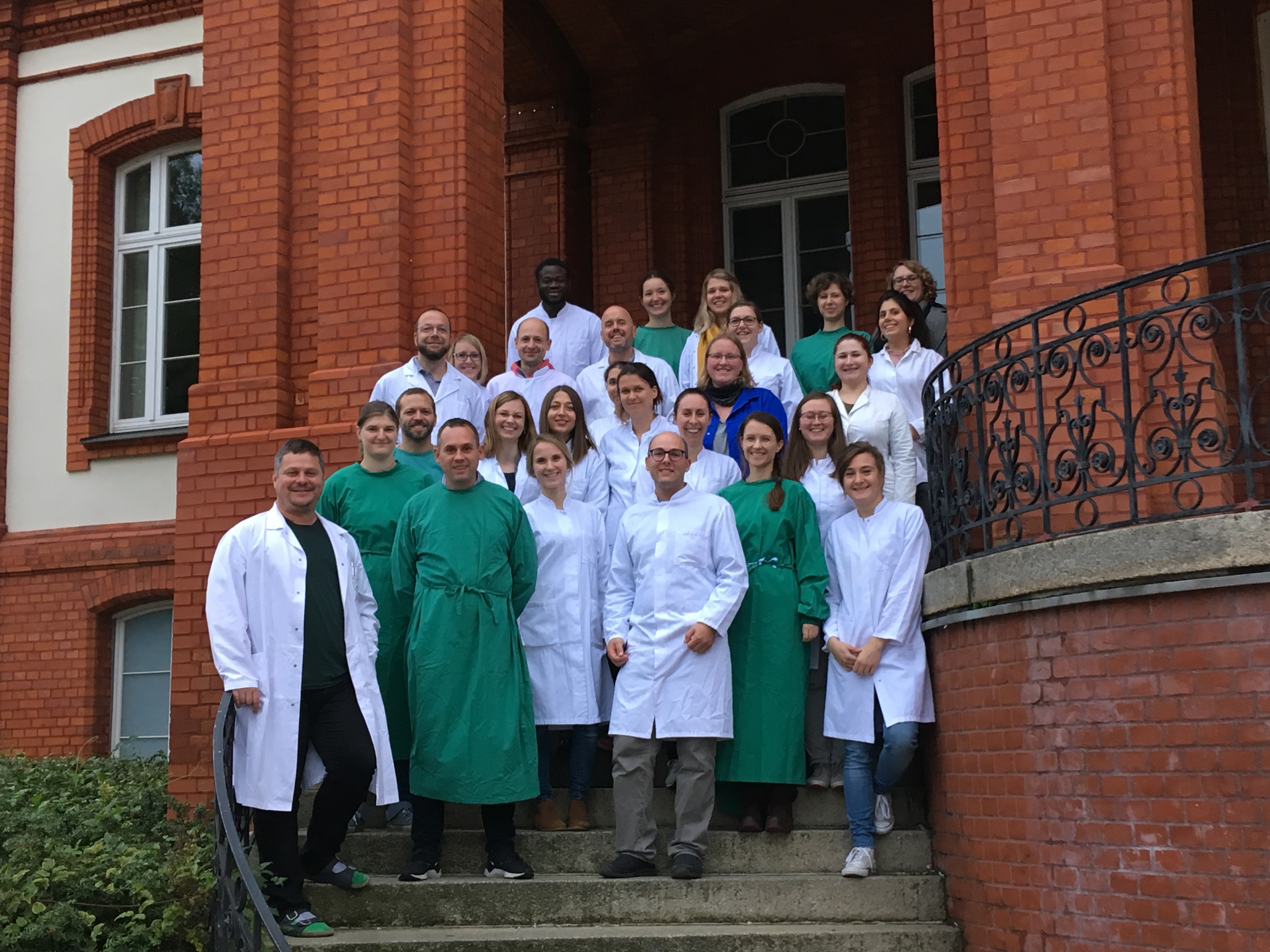 Menschgruppe auf den Stufen vor dem Institut für Anatomie der Uniklinik Rostock
