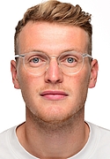 junger Mann mit blonden Haaren und einer Brille mit transparenten Rahmen 