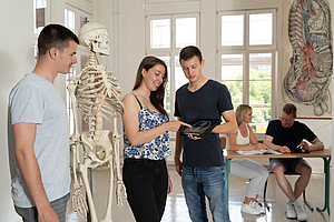 Studierende betrachten eine MRT-Aufnahme des Bauchraums auf einem Tablet